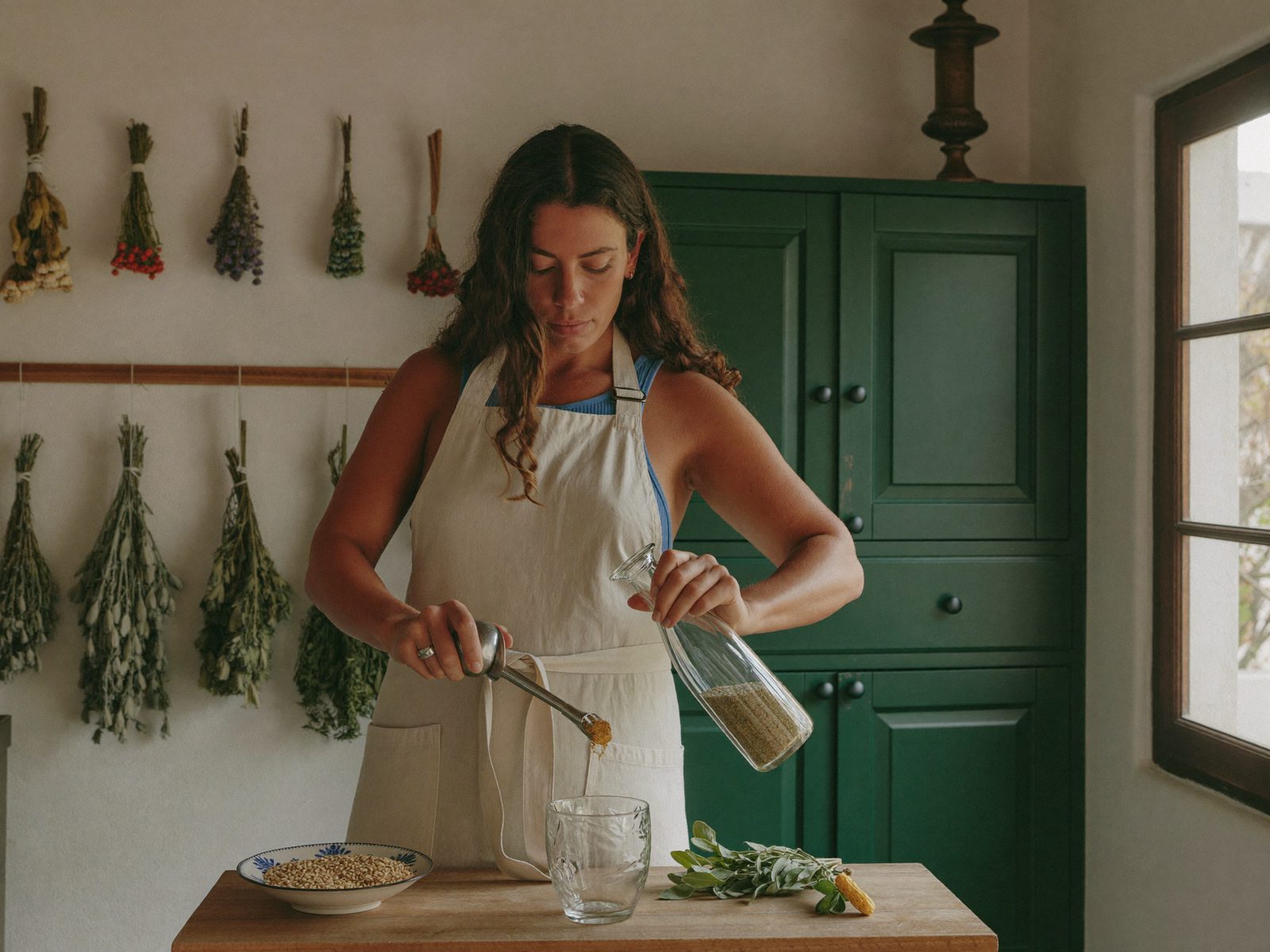 A herbalist tending oregano at the workshop bench